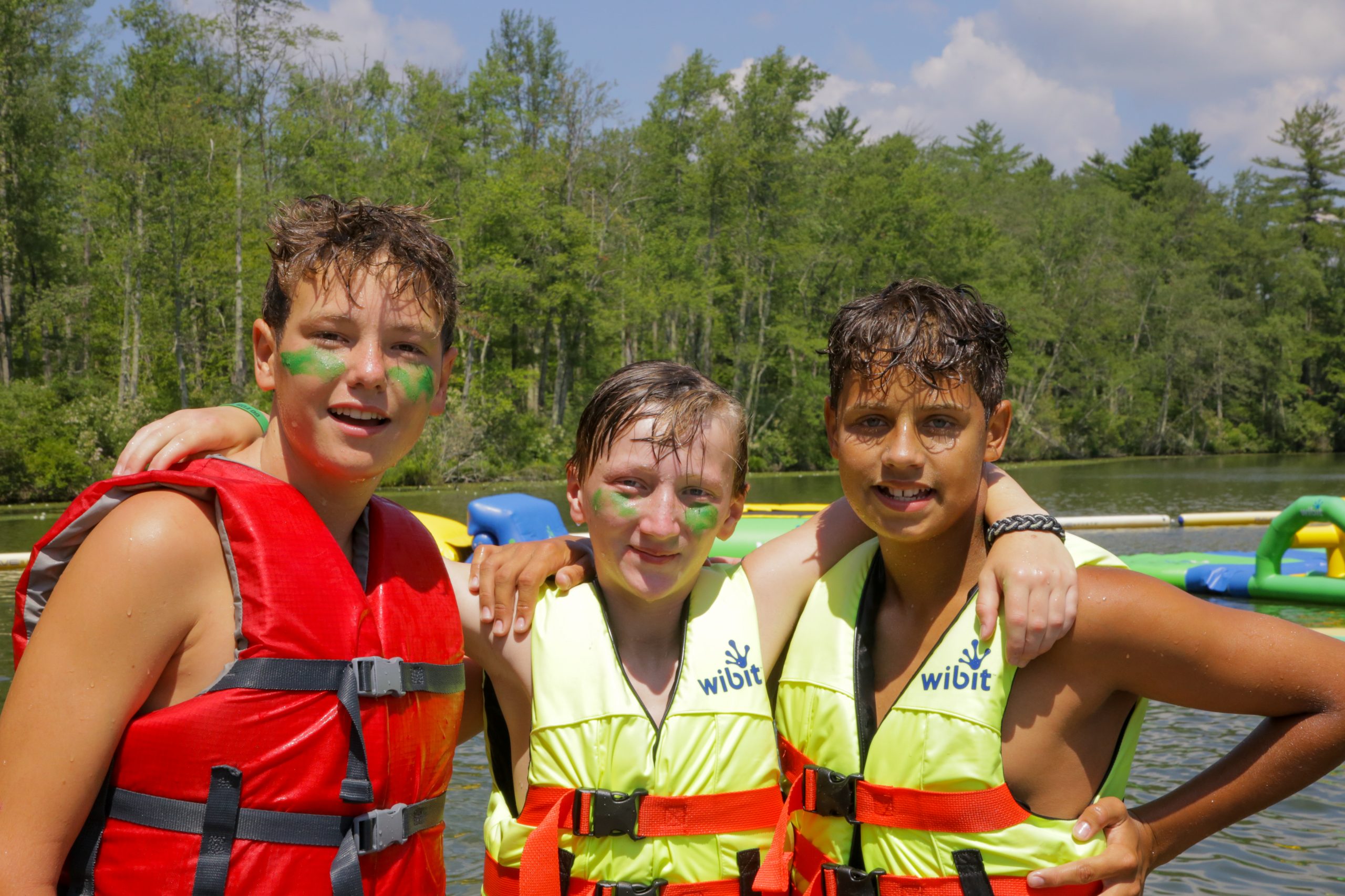 Three male campers enjoy a summer day by the lake, capturing the spirit of outdoor adventure, friendship, and fun in the sun.