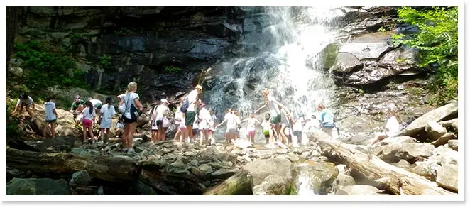 Campers exploring waterfall during adventure trips at Chestnut Lake Camp