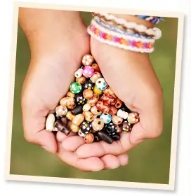 Hands holding colorful gemstones representing creativity and self-expression at Chestnut Lake Camp